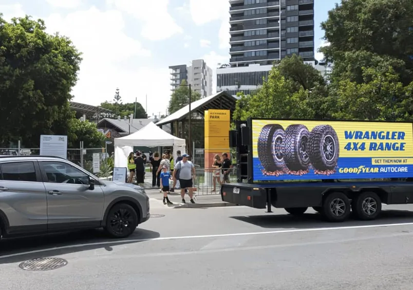 MOBO LED trailer running tire brand advertising on a city street