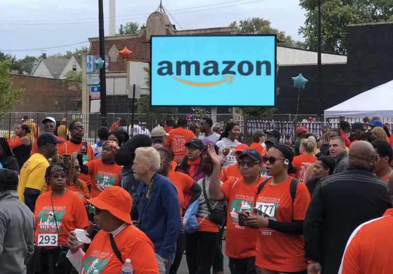 Community fun run crowd gathered around a MOBO LED screen trailer