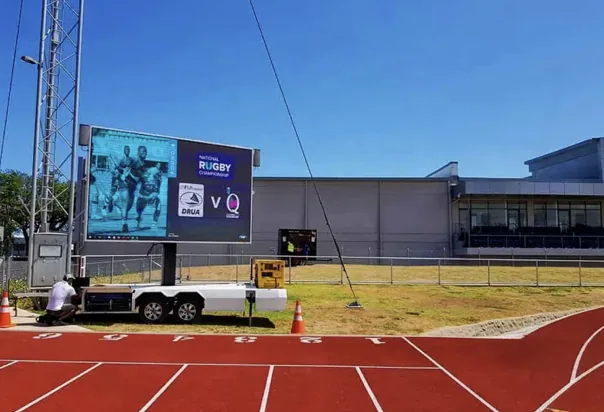 Large MOBO flatbed LED screen trailer serving a stadium track event