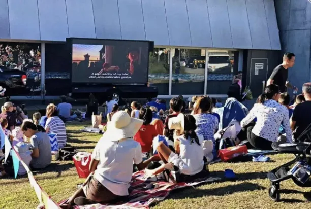 Crowd on a lawn watching an outdoor movie on a MOBO LED screen trailer