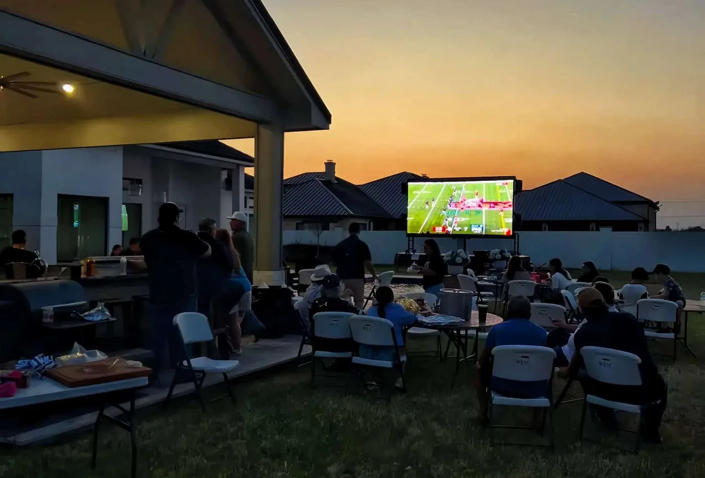 MOBO MB-10 LED screen trailer running a football watch party on a patio at sunset