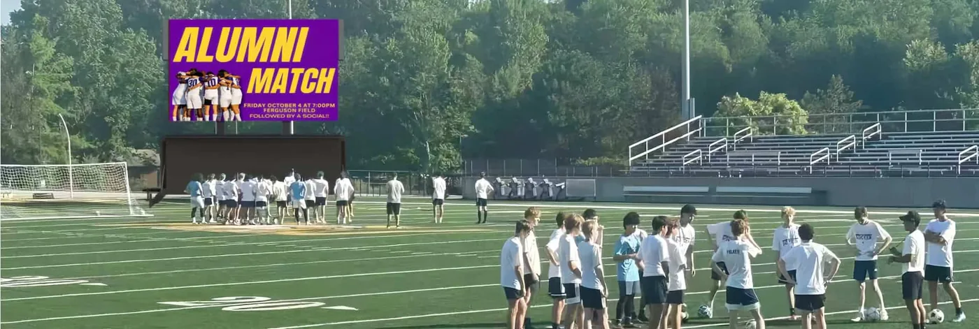 MOBO MB-60E enclosed LED jumbotron trailer at a school football field alumni match