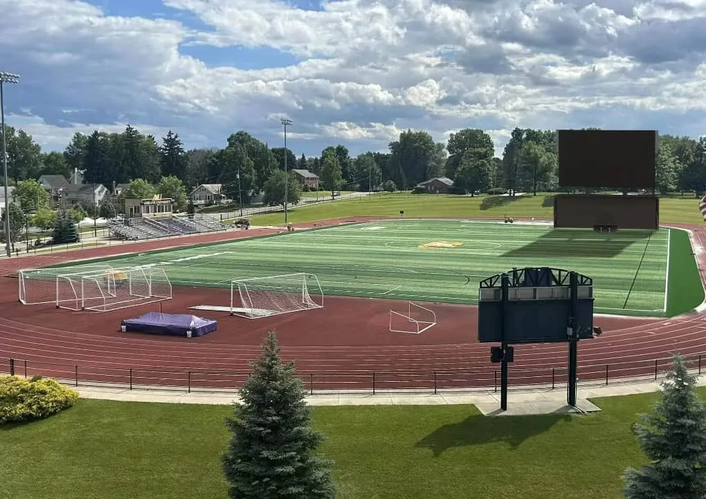 MOBO MB-60E LED jumbotron trailer beside a running track and athletic field