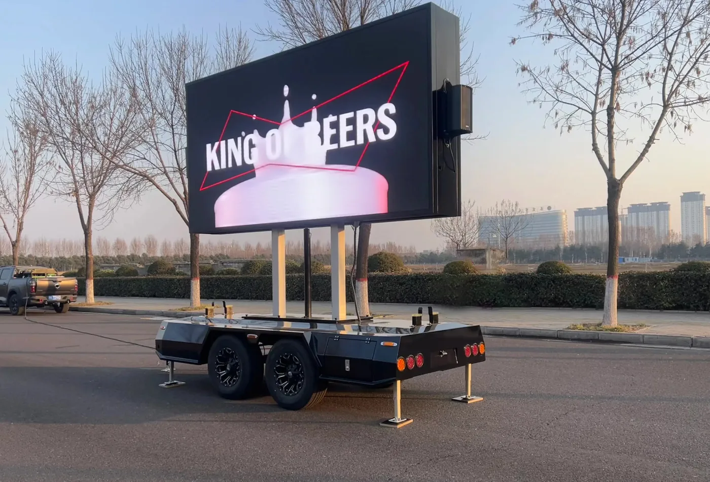 Side view of the MOBO MB-7D LED screen trailer displaying beer advertising